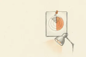 A printed radar chart pinned to an office wall with a thumbtack, desk lamp casting warm light on it